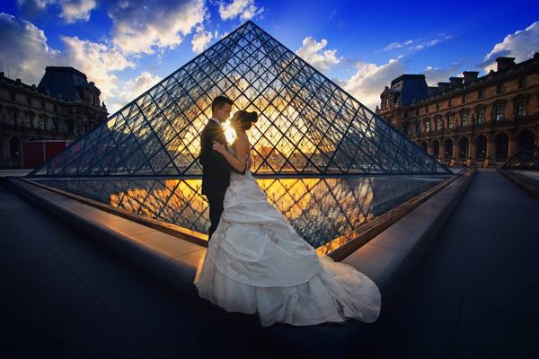 Des mariés devant la pyramide du Louvre